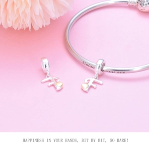 Detail of silver beaded bracelet featuring letter F charm and Unique You Are engraving