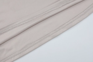 Detailed close-up of double-row stitching and light grey fabric texture on the vest