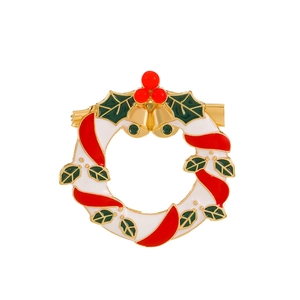 Broche couronne de Noël avec rubans rouges festifs et feuilles de houx vertes