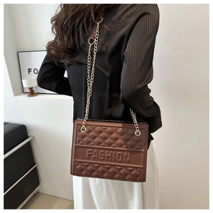 Detail of dark brown quilted bag with gold chain strap and embossed fashion letters
