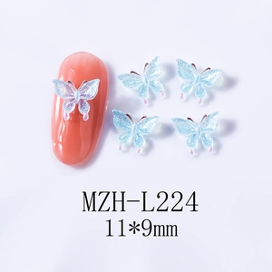 Macro detail of 11x9mm blue resin butterfly nail art charm with shimmer and pink accents