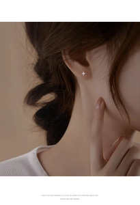 Close-up of minimalist S925 sterling silver four-pointed star stud earring with white zircon