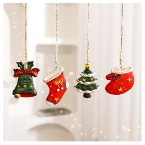 Detailed view of resin Christmas ornaments including bells, socks, and trees on twine