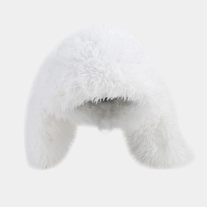 Close-up of white plush faux fur texture on warm winter hat with fluffy ear flaps