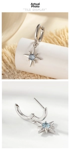 Macro detail of silver starburst drop earrings with light blue gemstone and hoop