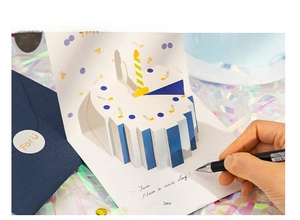 Close-up of 3D birthday cake card with smooth writing surface and elegant blue envelope