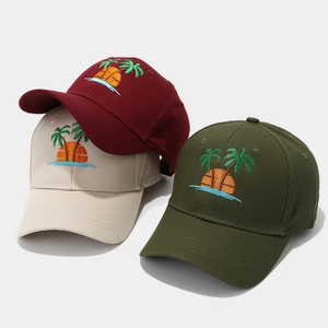 Détail de la broderie de palmier colorée sur des casquettes en coton de divers coloris