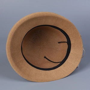 Detail view of woven sun hat interior featuring black sweatband and adjustable cord