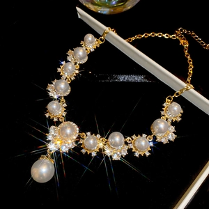 Elegant gold necklace with white pearl and sparkling crystals in a luxury jewelry box