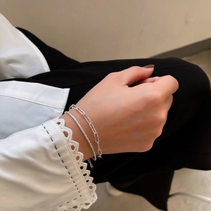 Dettaglio di un bracciale a catena a due strati in argento sterling S925 sul polso di donna