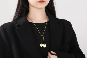 Golden snake chain Y-necklace with double heart pendants on a female model