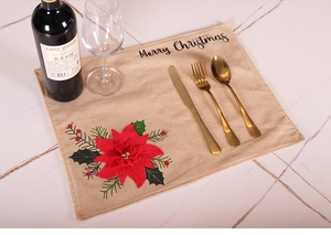 Detail of Christmas poinsettia embroidery and Merry Christmas text on linen placemat