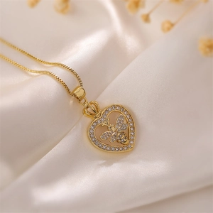 Close-up of gold plated heart necklace with zircon border and crown bee detail on silk
