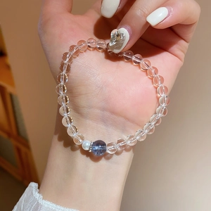 Détail macro d'un bracelet en perles de cristal blanc avec perle et pierre bleue