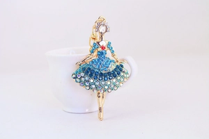 Detailed close-up of ballet girl keychain with blue and white rhinestones on gold metal