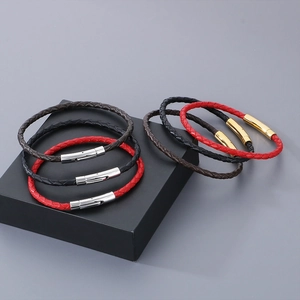 Détail de bracelets en cuir tressé rouge, noir et marron avec fermoirs magnétiques polis