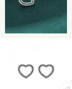 Detail of vintage sterling silver heart studs featuring textured black dot inlay