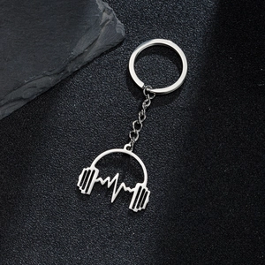 Polished silver metal keychain with headphone and heartbeat pendants on black stone