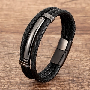Multilayer braided black leather bracelet with gunmetal magnetic clasp on wood background