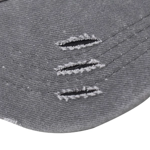 Detail of distressed brim on charcoal washed cotton baseball cap with ripped effects