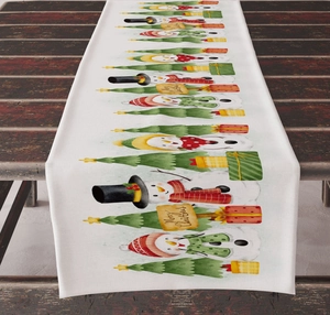 Detail view of linen Christmas table runner with snowman and festive tree patterns