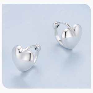 Macro shot of minimalist S925 sterling silver heart hoop earrings with authentic hallmark