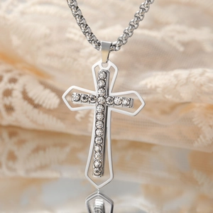 Macro shot of silver-colored hip-hop cross pendant with shiny cubic zirconia stones