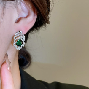 Détail de la boucle d'oreille feuille argentée avec zircons et pierre goutte verte
