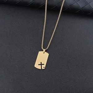 Detail of gold dog tag pendant with hollow cross and blue zircon on black leather
