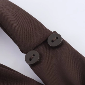 Detailed close-up of dark brown knit dress fabric featuring two matching round buttons