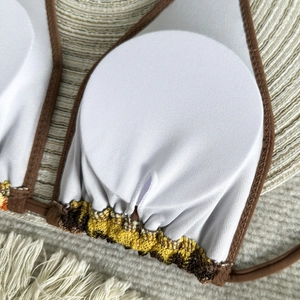 Detail of crochet bikini top with removable chest pad and striped knit texture