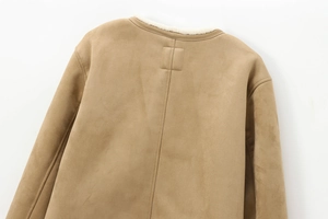 Detail der kamelbraunen Wildlederjacke mit weißem Kunstfellfutter und feinen Nähten
