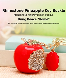 Detailed view of red enamel apple keychain with sparkling rhinestone accents and gold ring