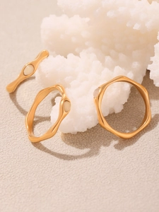 Detail of 18k gold plated wave rings featuring faceted rose quartz on coral decor