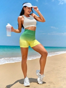 Detail of high waisted scrunch butt yoga shorts in green gradient with ribbed tank top