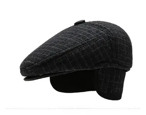 Detail of grey plaid flat cap showing the thick wool texture and foldable ear flaps