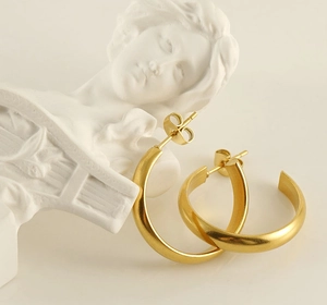 Detailed view of matte golden hoop earrings with high-quality brushed metal texture