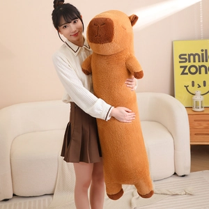 Detailed view of extra long brown capybara plush pillow held by a person in cozy setting