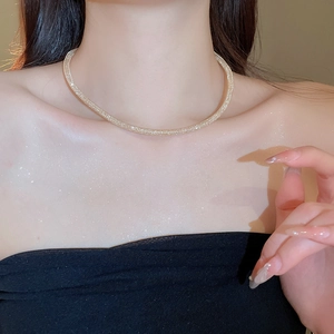 Detail of champagne gold zircon mesh necklace with sparkling finish on model neck