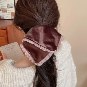 Detail of brown velvet scrunchie with pink lace edges shown in a cozy home setting