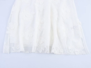 Detail of white mesh dress fabric featuring 3D floral embroidery and lace textures