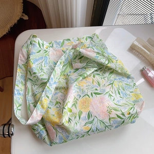 Detail of floral cotton tote bag with vintage pastoral print on white surface