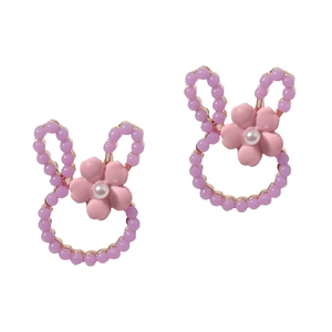 Detailed close-up of rabbit-shaped beaded earrings with pink flower and white pearl