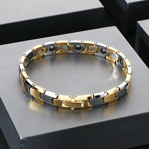 Détail d'un bracelet magnétique bicolore avec maillons dorés et gris anthracite