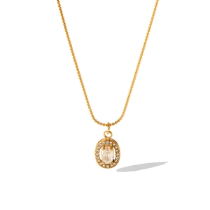 Close-up of 18K gold stainless steel necklace with oval clear crystal pendant and halo