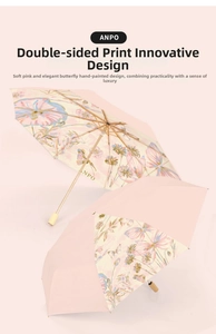 Detail of pink folding umbrella with floral butterfly print and gold metal frame