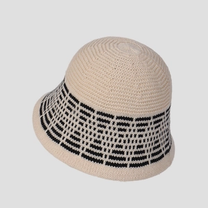 Detail showing knit diamond patterns on an off-white and black wool bucket hat