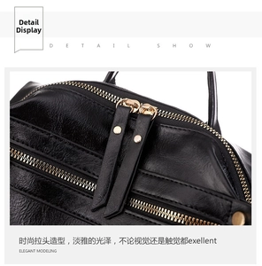 Close-up of premium black leather texture with gold double zippers and hardware