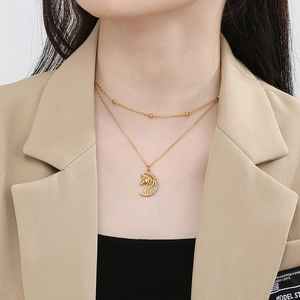 Close-up of double-layer 18K gold plated necklace with unicorn and star pendant