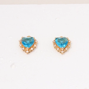 Close-up of heart-shaped blue zircon stud earrings with crystal halo and gold plating